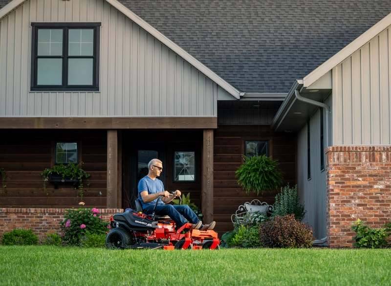Gardening Professional at Work with Riding Mower Person mowing green grass with a heavy-duty riding mower.